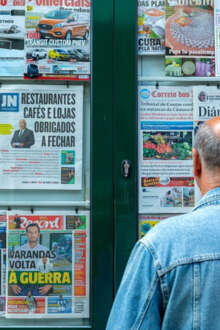 Pessoas em ponto de venda de jornais